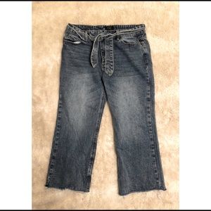 Lira cropped wide leg jeans with a belt.